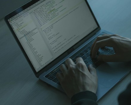 Hands typing code on a laptop keyboard