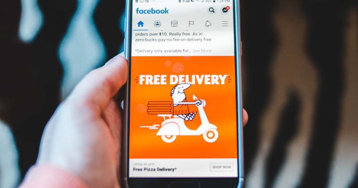 Hand holding smartphone showing a mobile ad on screen